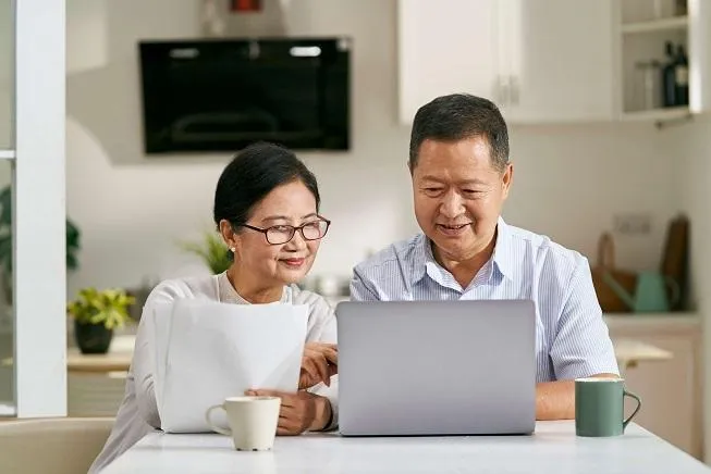 Singaporean couple reviewing retirement finances and CPF payout plans at home
